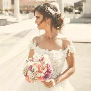 Mariée tenant son bouquet, voile au vent