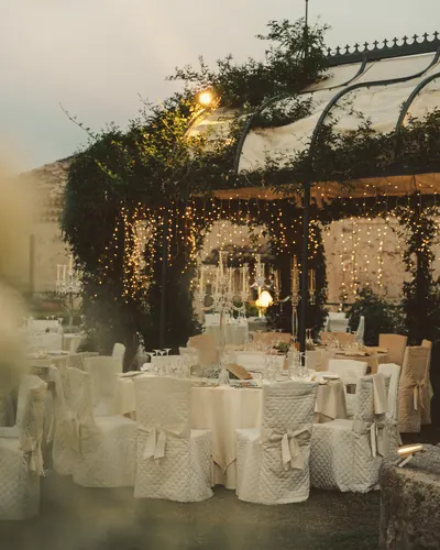 Terrasse dressée sous des guirlandes lumineuses